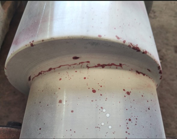 Grieta detectada mediante líquidos penetrantes en eje de acero industrial